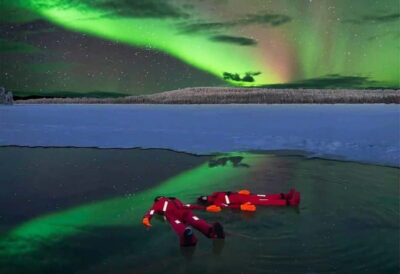 Ice Floating in Forest Lake with Aurora Borealis